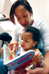 mom reading a board book to child